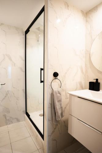 une salle de bain avec douche et lavabo dans l'établissement La Bastide Bleue La Ciotat, à La Ciotat