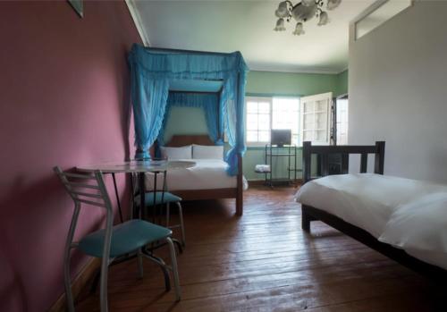 a bedroom with a bed and a table and chair at La Casa de Algodon in Huacho