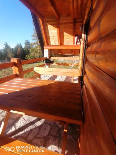a bench in a wooden cabin with a table at Vila Dajana Zminica in Žabljak