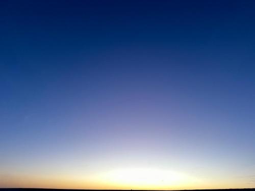 an image of the sun setting over the horizon at La Siwa in Siwa