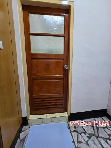 a wooden door in a room with a tile floor at 高鐵中彰309民宿 in Changhua City