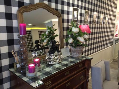 a dressing table with candles and flowers and a mirror at Hotel Jávea in Jávea