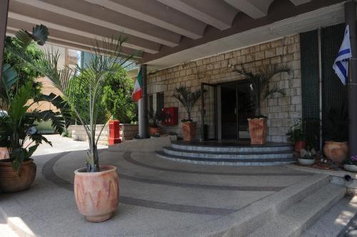 un bâtiment avec des escaliers et des plantes en pot devant lui dans l'établissement Tabar Hotel, à Nazareth