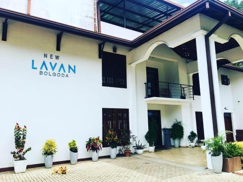 a white building with potted plants in front of it at New Lavan Bolgoda in Piliyandala