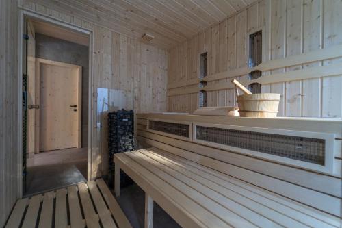 a sauna with a wooden bench and a door at Pine chalet in Smižany