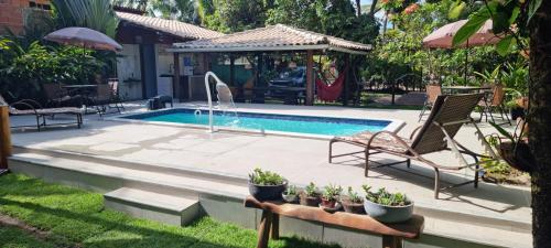 a swimming pool in a yard with two lawn chairs at Casa Praia dos Anjos in Barra Grande