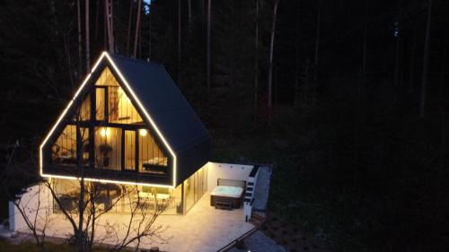 a small house with a pitched roof at night at Pine chalet in Smižany