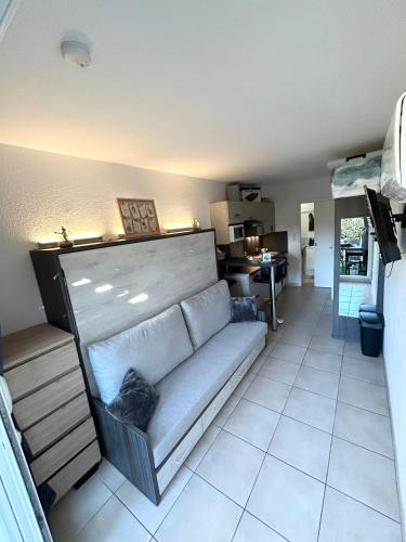un salon avec un canapé et une cuisine dans l'établissement Studio résidence Tennis Village Cap D’Agde, au Cap d'Agde