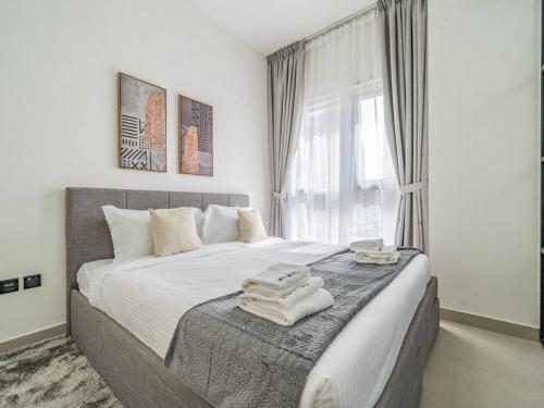 a bedroom with a large bed with towels on it at Dubai Hills estate - 1Bedroom Apt in Dubai