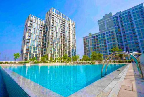 a large swimming pool with two tall buildings at Dubai Hills estate - 1Bedroom Apt in Dubai