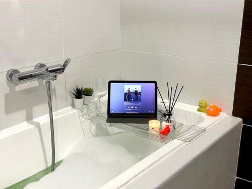 a laptop computer sitting on a bath tub in a bathroom at Encorp Marina Puteri Harbour Bathtub Netflix in Iskandar Puteri