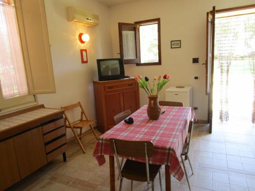 Cette chambre dispose d'une table avec un vase de fleurs. dans l'établissement Villa Maria, à Marausa