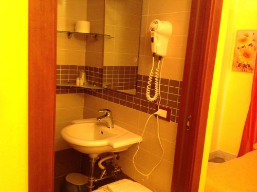 uma casa de banho com um lavatório e um telefone na parede em Bed & Breakfast Federico II em Foggia