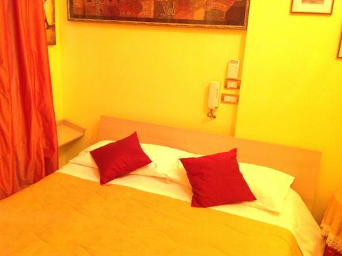 um quarto com uma cama com duas almofadas vermelhas em Bed & Breakfast Federico II em Foggia