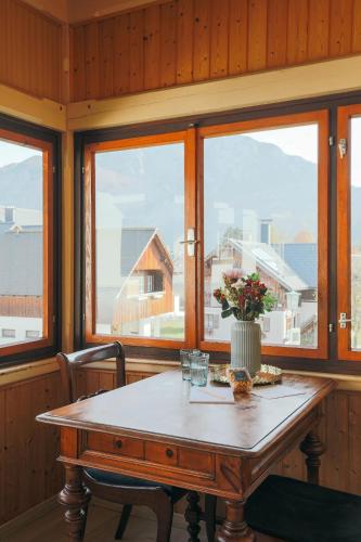 a wooden table with a vase of flowers on it at Domizil Ausseerland - Your Austrian Home in Altaussee