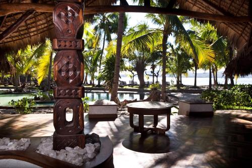 a wooden pillar in a resort with a table at Ravintsara Wellness Hotel in Ambaro