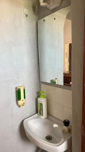 a bathroom with a white sink and a mirror at The Truenorth of Diani in Mombasa