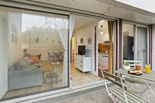 d'un salon avec une grande porte coulissante en verre. dans l'établissement Parenthèse Urbaine -1mn Métro - Paris - Wifi - commerces - balcon vue calme- travail - famille, à Maisons-Alfort