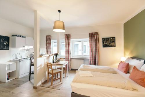 a bedroom with a bed and a kitchen with a table at Domizil Ausseerland - Your Austrian Home in Altaussee