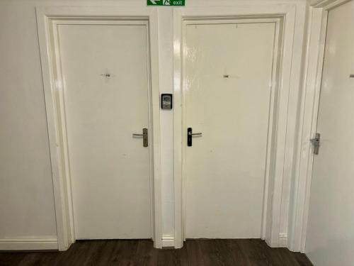 two white doors in a room with wood floors at Stainless Guests house in Dudley