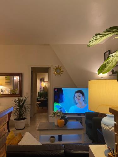 - un salon avec une télévision à grand écran dans l'établissement Appartement 10e Paris, à Paris