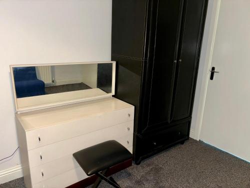 a dresser with a mirror and a chair in a room at Stainless Guests house in Dudley