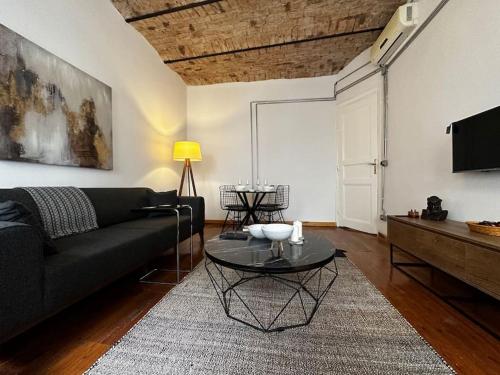 a living room with a black couch and a table at Historical Flat in Galata - Tatar Beyi Street in Istanbul