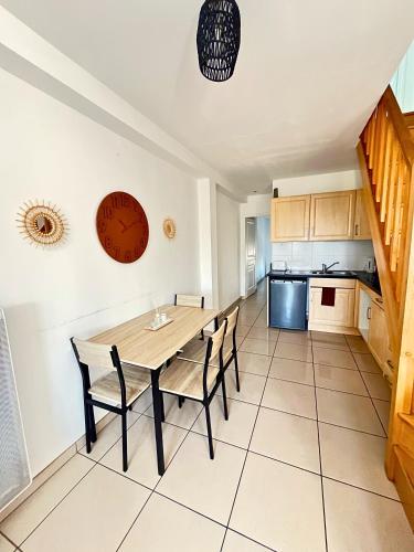 une cuisine et une salle à manger avec une table et des chaises dans l'établissement Duplex-Trois pas de la Gare, à Sartrouville
