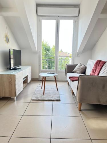 a living room with a couch and a table at Duplex-Trois pas de la Gare in Sartrouville