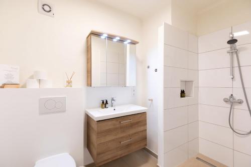 a white bathroom with a sink and a shower at Domizil Ausseerland - Your Austrian Home in Altaussee