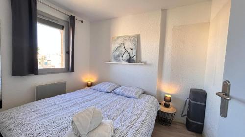 une chambre avec un lit et une fenêtre dans l'établissement Appartement Le Barcares avec vue sur mer de type T2 location Arrivée à partir de 15h départ maximum à 11h Location du samedi au samedi juillet et août, au Barcarès