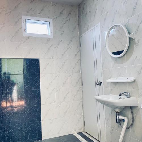 a bathroom with a sink and a mirror and a shower at Panutsaya Homestay in Wang Nam Khieo