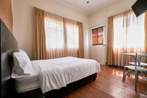 a bedroom with a bed and a table and window at La Casa de Algodon in Huacho