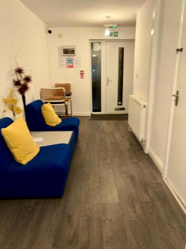 a living room with a blue couch and a hallway at Stainless Guests house in Dudley