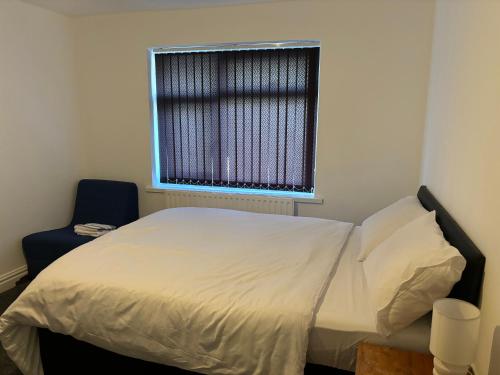 a bed in a room with a window and a chair at Stainless Guests house in Dudley