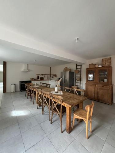 une salle à manger avec une longue table et des chaises dans l'établissement Gite La Famille 4 etoiles Domaine Grange Lecomte, à Tournes