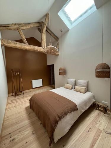 - une chambre avec un grand lit et une lucarne dans l'établissement Gite La Famille 4 etoiles Domaine Grange Lecomte, à Tournes