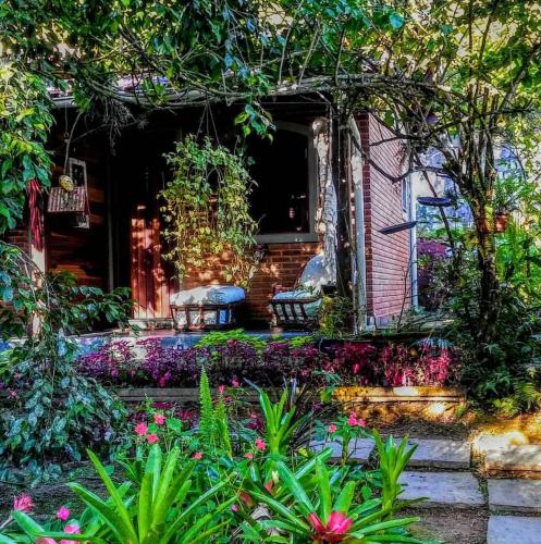 a garden with two benches in front of a house at Pousada Romântica Serra da Mata in Penedo