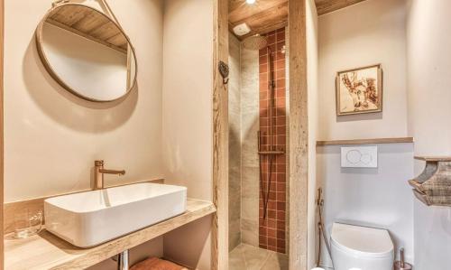 une salle de bain avec un lavabo, des toilettes et un miroir dans l'établissement Chalet prestige Saint Gervais les Bains, à Saint-Gervais-les-Bains