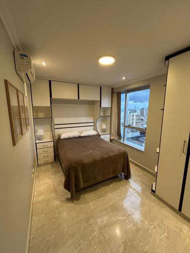 una camera da letto con un letto e una grande finestra di Apartamento 1 quarto - Taguatinga Centro - Lazer Completo, Garagem, ao lado do metrô a Brasilia