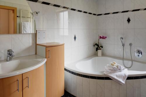 a bathroom with a tub and a sink and a shower at Residence Ladurn in Tirolo