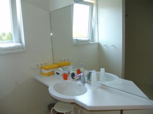 uma casa de banho com um lavatório branco e um espelho. em Hotel Pension Futterknecht em Burgau