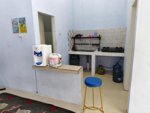 a kitchen with a counter and a stool in a room at Homestay Pandan in Halangan