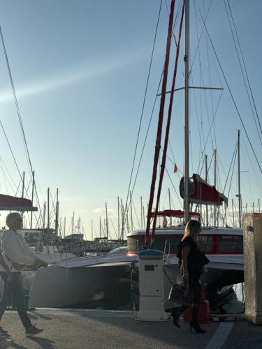 un homme et une femme debout à côté d'un voilier dans l'établissement Appartement 50m de la plage et toutes commodités, plein centre ville et silencieux, à La Grande Motte