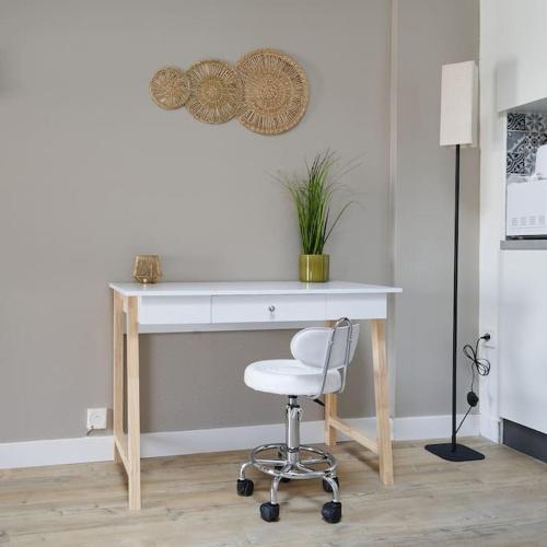 un bureau blanc avec une chaise et une plante dans l'établissement Les Halles by Paul Riquet 1609, à Béziers