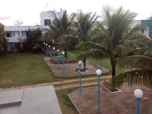 a row of street lights in a park with palm trees at Hotel Pousada Recanto in Ilha Comprida