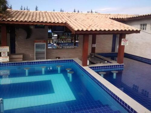 a large swimming pool with a house and a building at Hotel Pousada Recanto in Ilha Comprida