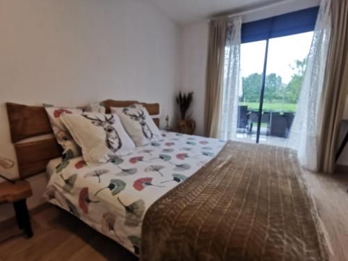 ein Schlafzimmer mit einem Bett und einem großen Fenster in der Unterkunft Le Pti'Fernin, Gîte de Sologne in Saint-Viâtre