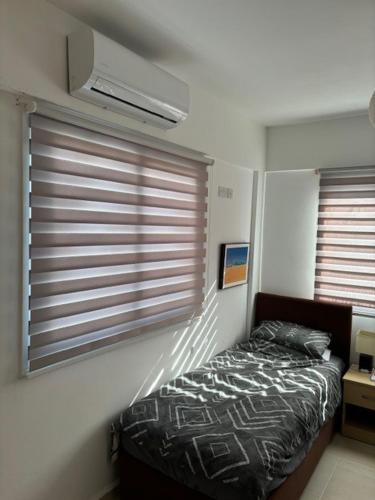 a bedroom with a bed and a window with blinds at Sunset View Penthouse Apartment 2 Bedrooms Tatlisu in Akanthou
