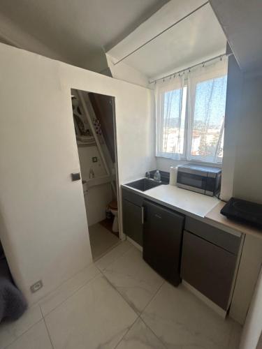 une petite cuisine avec un évier et une fenêtre dans l'établissement Studio centre Nice, à Nice